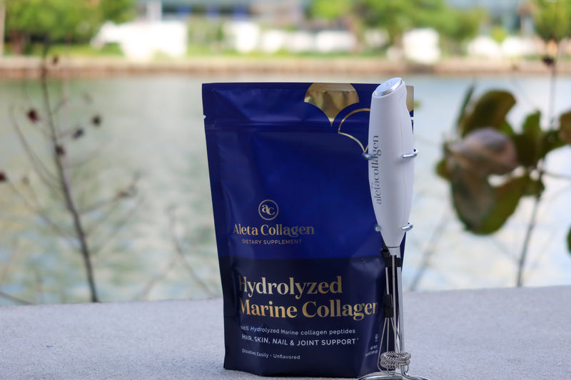 Aleta Collagen hydrolyzed marine collagen package with a pen on a surface by a body of water.